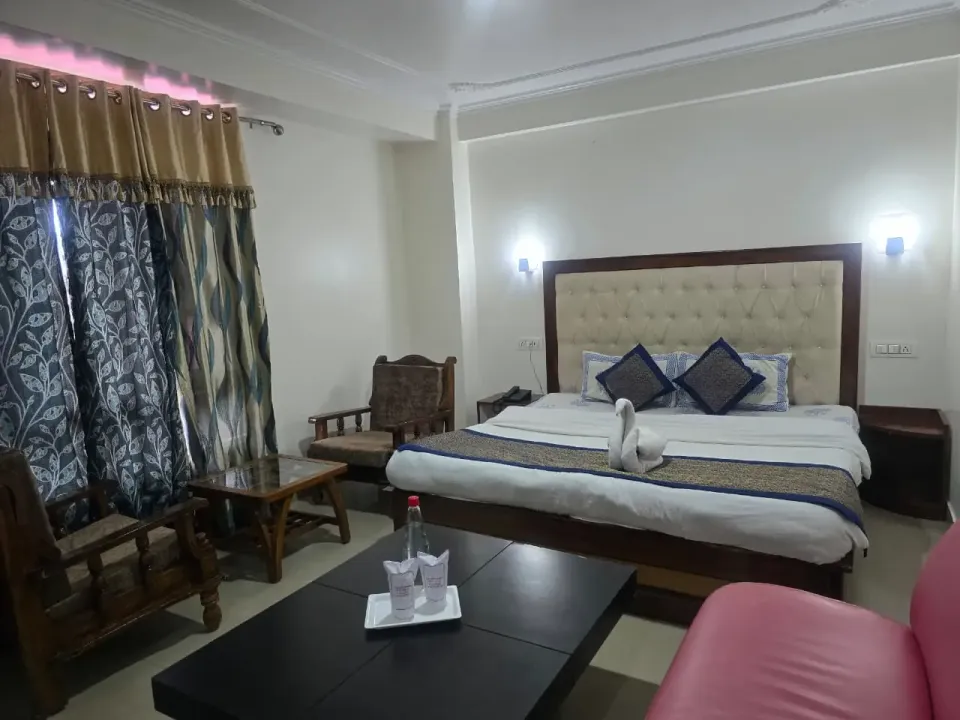 Family suite with a sitting area, sofa, centre table and towel swan on the bed